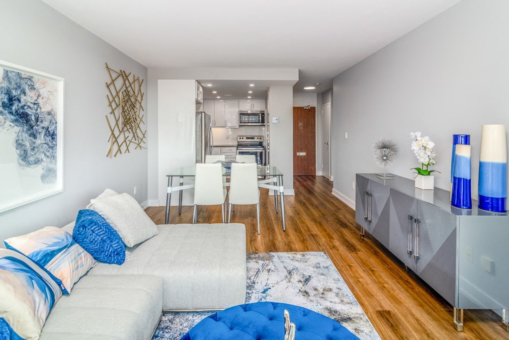 Open concept living and dining room staged with furniture. The kitchen is open from the dining room.