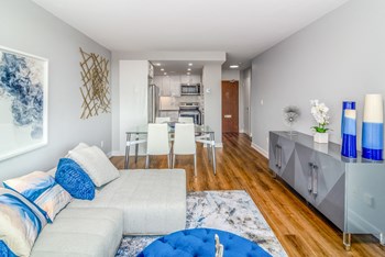 Open concept living and dining room staged with furniture. The kitchen is open from the dining room. - Photo Gallery 2