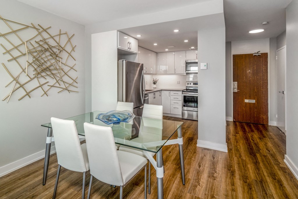 Open concept kitchen and dining room staged with furniture. The kitchen is open from the dining room.