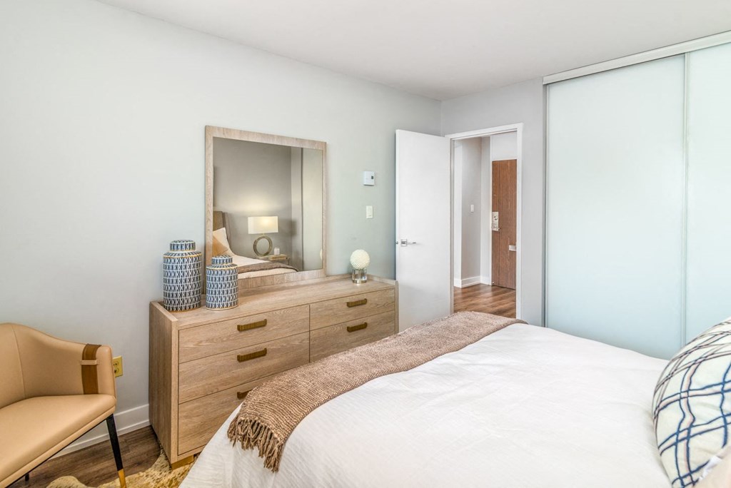 Sunny bedroom showing a bed and dresser.