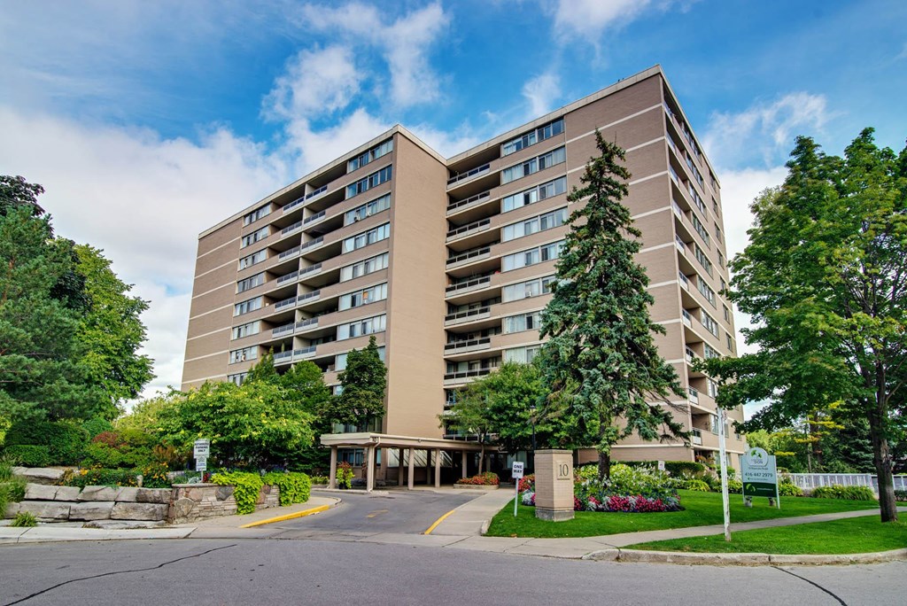 a large building with trees in front of it on a street
