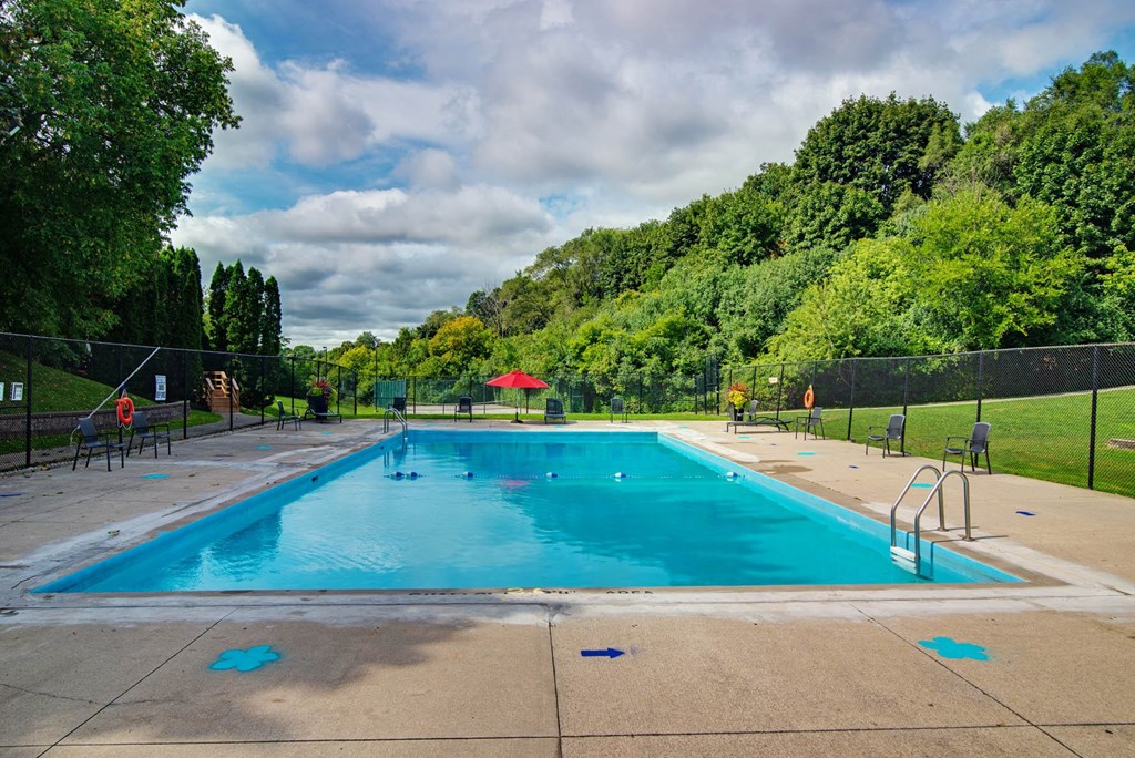 a swimming pool with trees and a fence around it