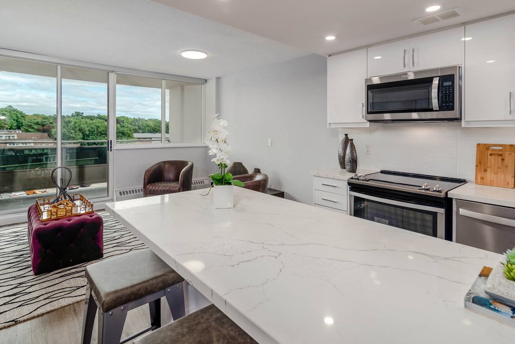 a white kitchen with a large counter top and a microwave