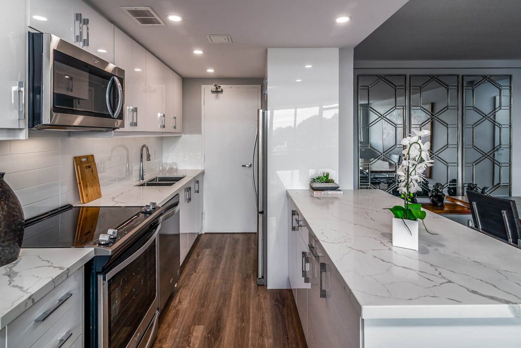 a kitchen with marble counter tops and white cabinets