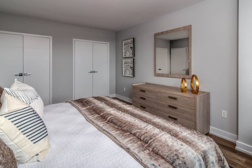 a bedroom with a bed and a dresser with a mirror