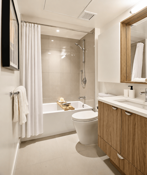 A white toilet sits next to a white sink in a modern bathroom.