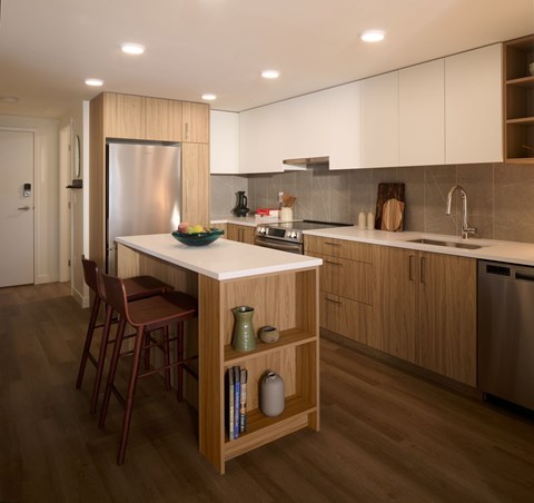 A kitchen with a white island and wooden cabinets.