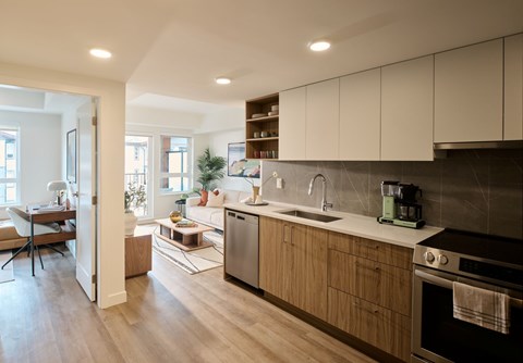 A modern kitchen with wooden cabinets and a black oven.