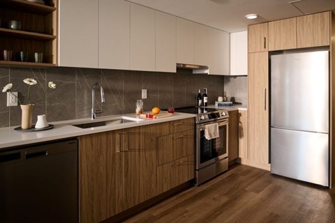 A modern kitchen with wooden cabinets and stainless steel appliances.