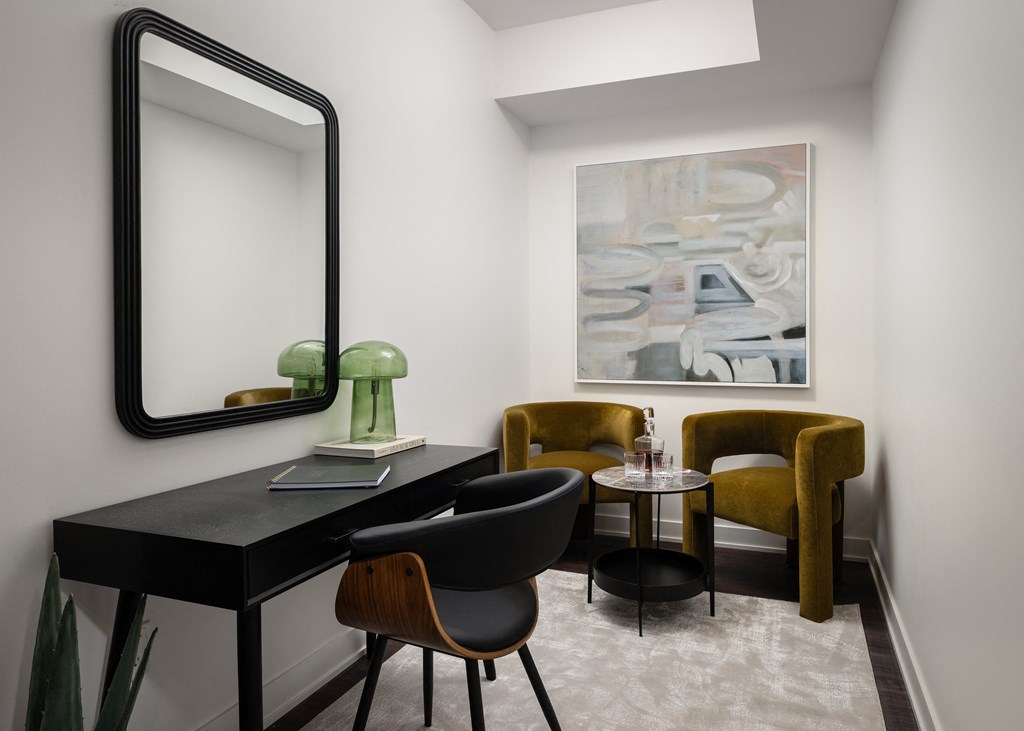 a room with a desk and chairs and a large mirror