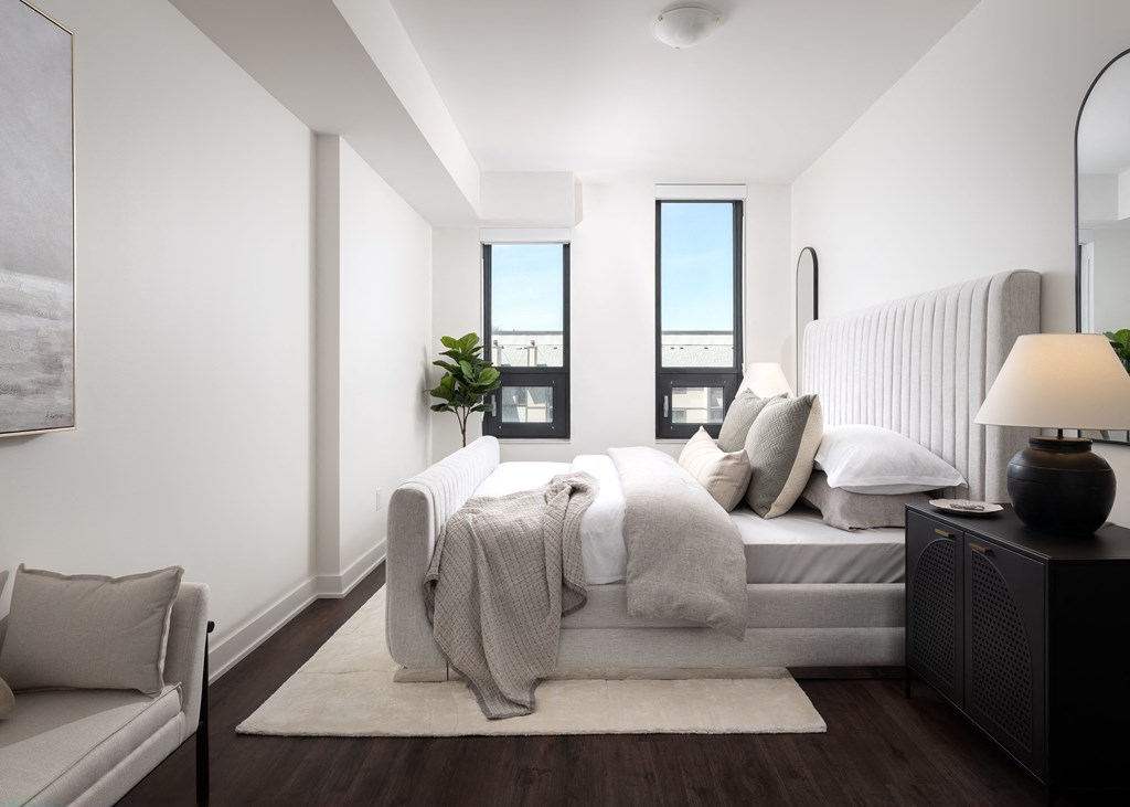 a bedroom with white walls and a bed with pillows and blankets