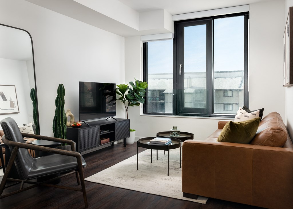 a living room with a brown couch and a television