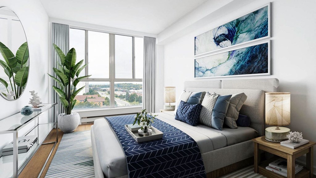 Staged bedroom with beautiful artwork, plants and two night stands