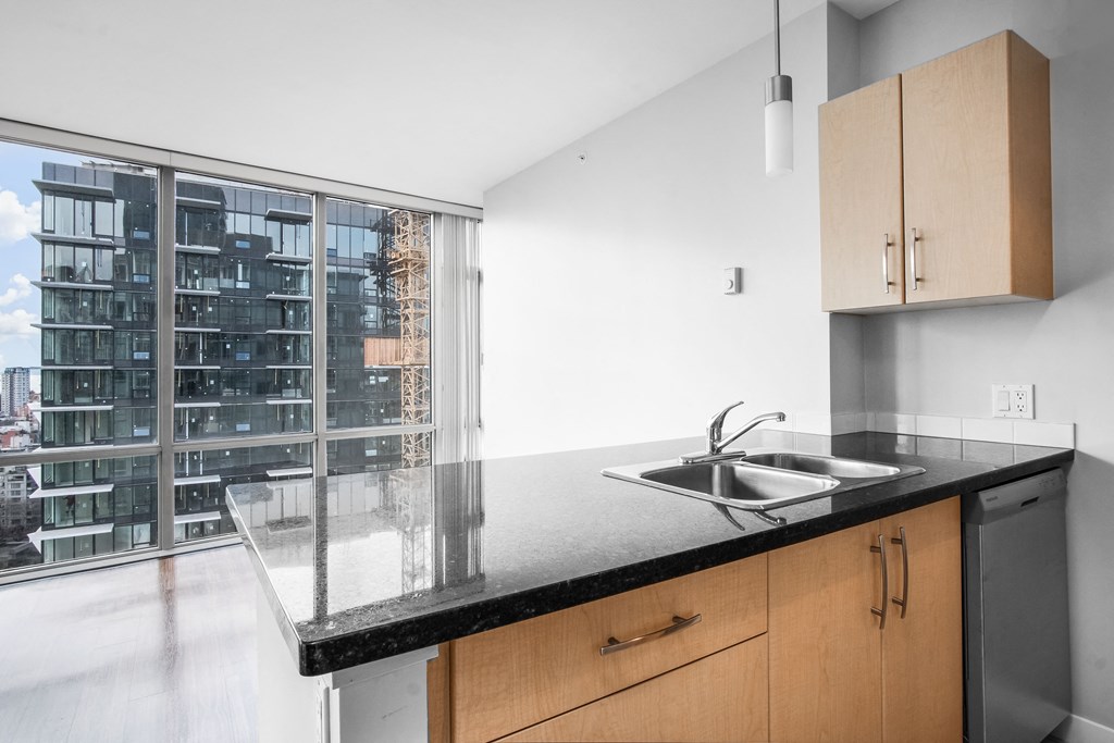View from the kitchen of suite 2304 from teh kitchen, looking across the living room out to the floor-to-ceiling window views.