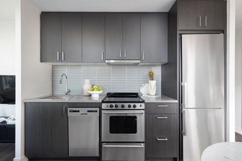 A modern kitchen with a stainless steel refrigerator and oven.