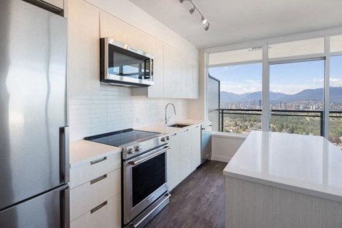 a kitchen with a stove and a microwave and a window
