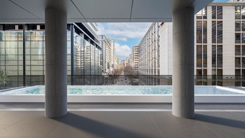 a pool in the middle of a building with buildings in the background