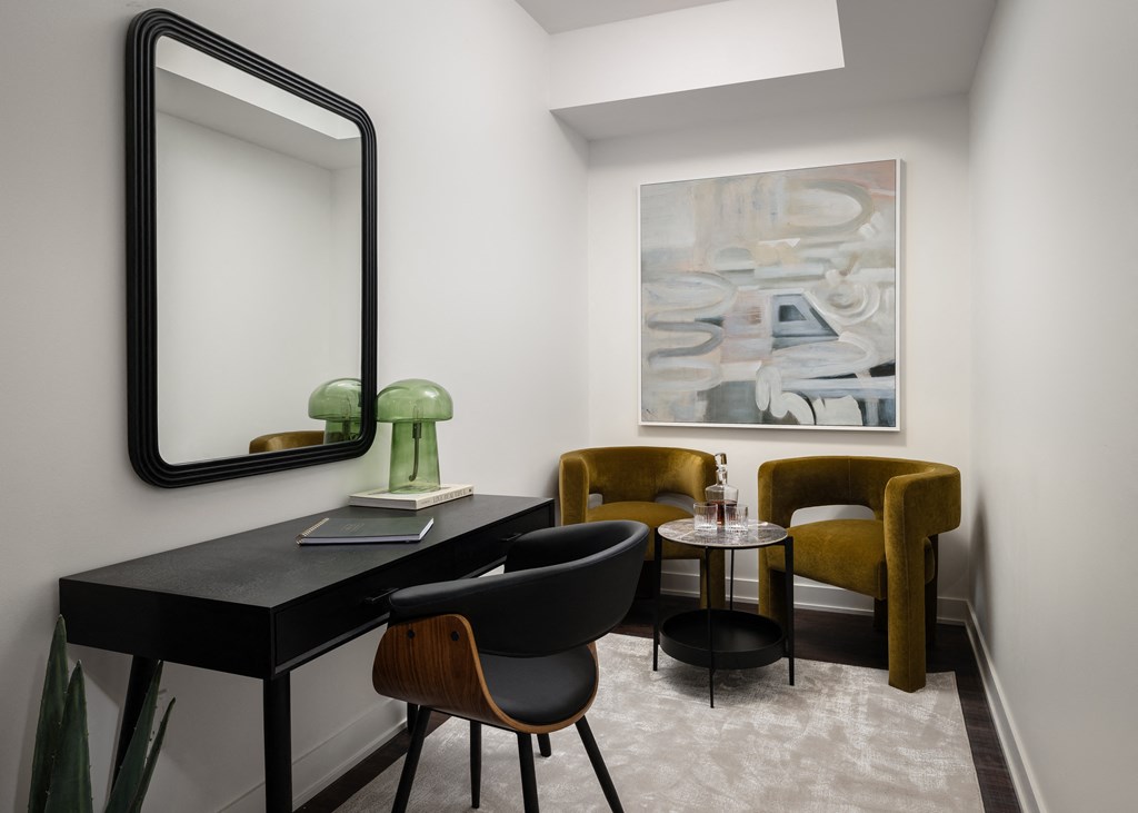 a room with a desk and chairs and a large mirror