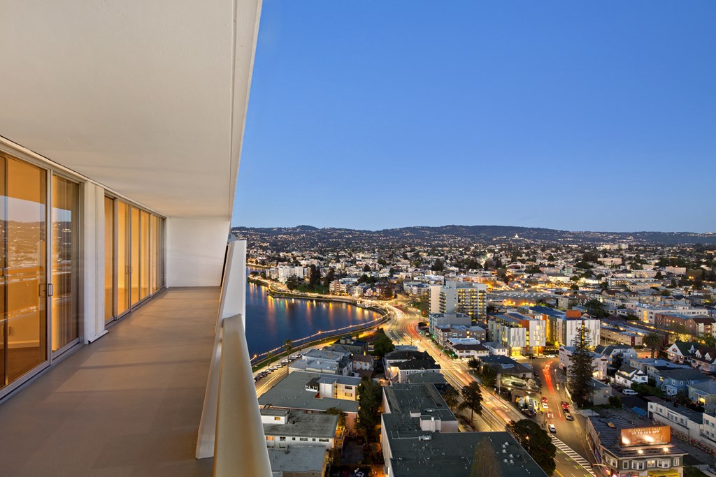 a view of the city from the balcony of a condo overlooking a river and city