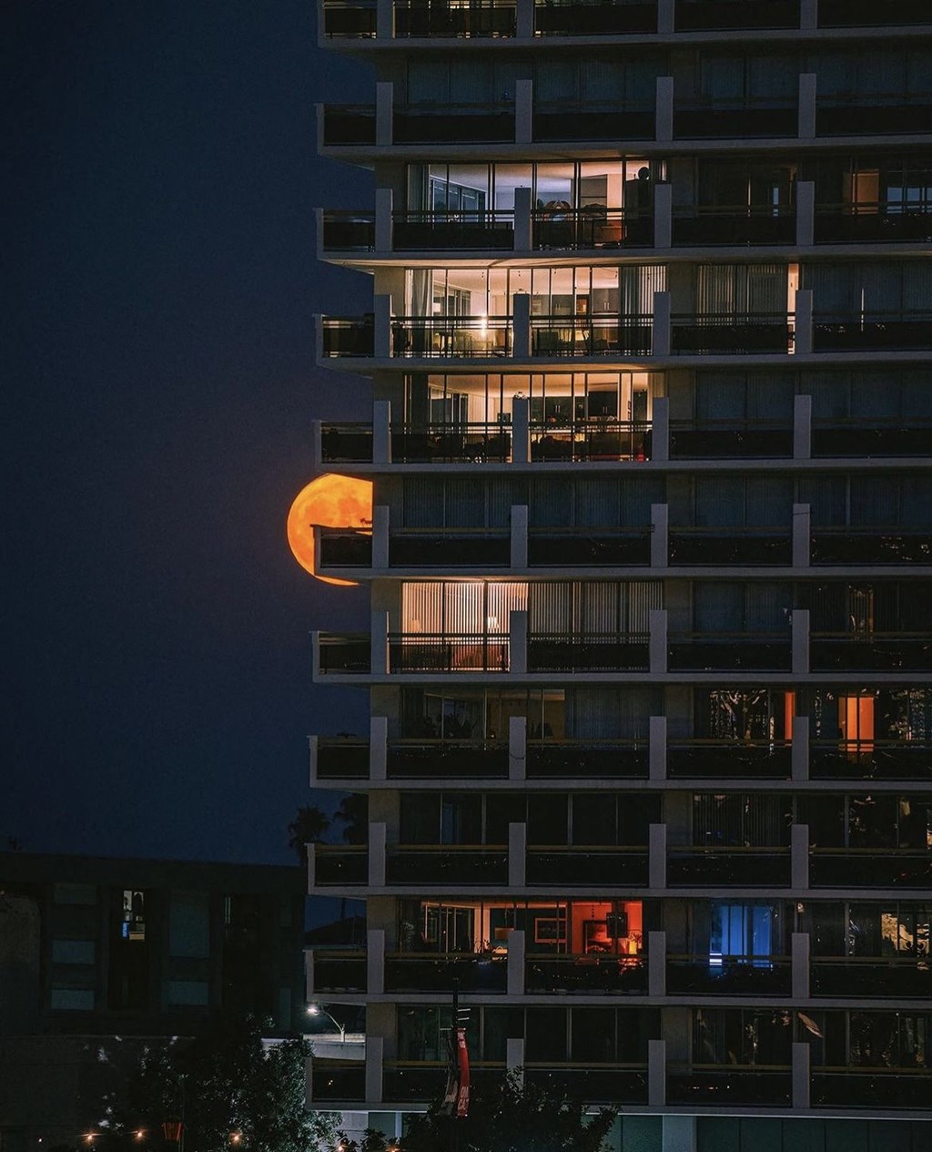 the moon is projected on the side of a building at night