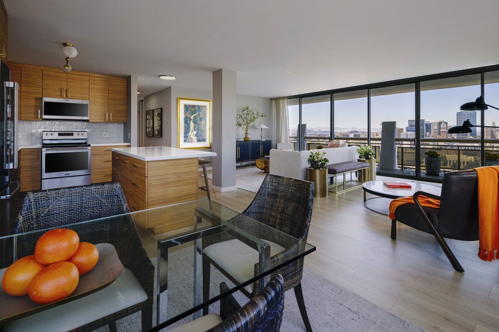 a living room and kitchen with a glass table and chairs