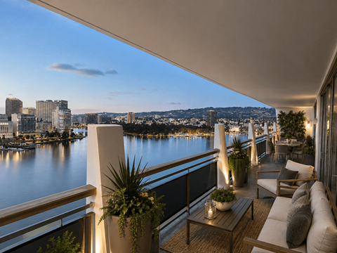 A balcony with a view of a city skyline at dusk.