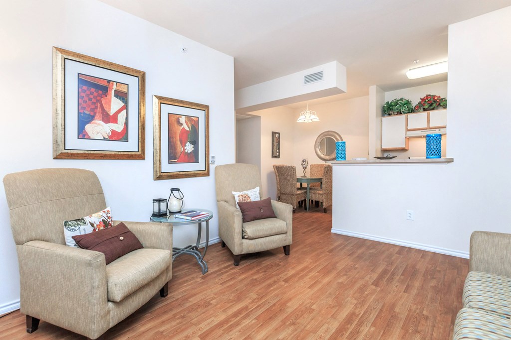 a living room with couches and chairs and a kitchen with a dining room table