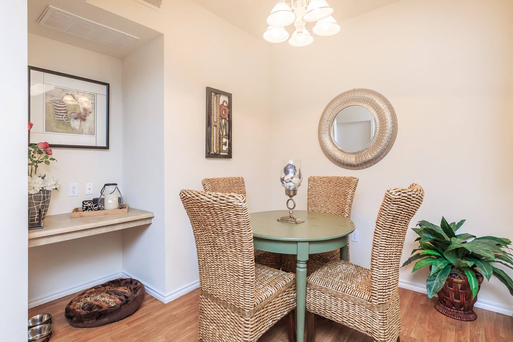 a dining room with wicker chairs and a green table