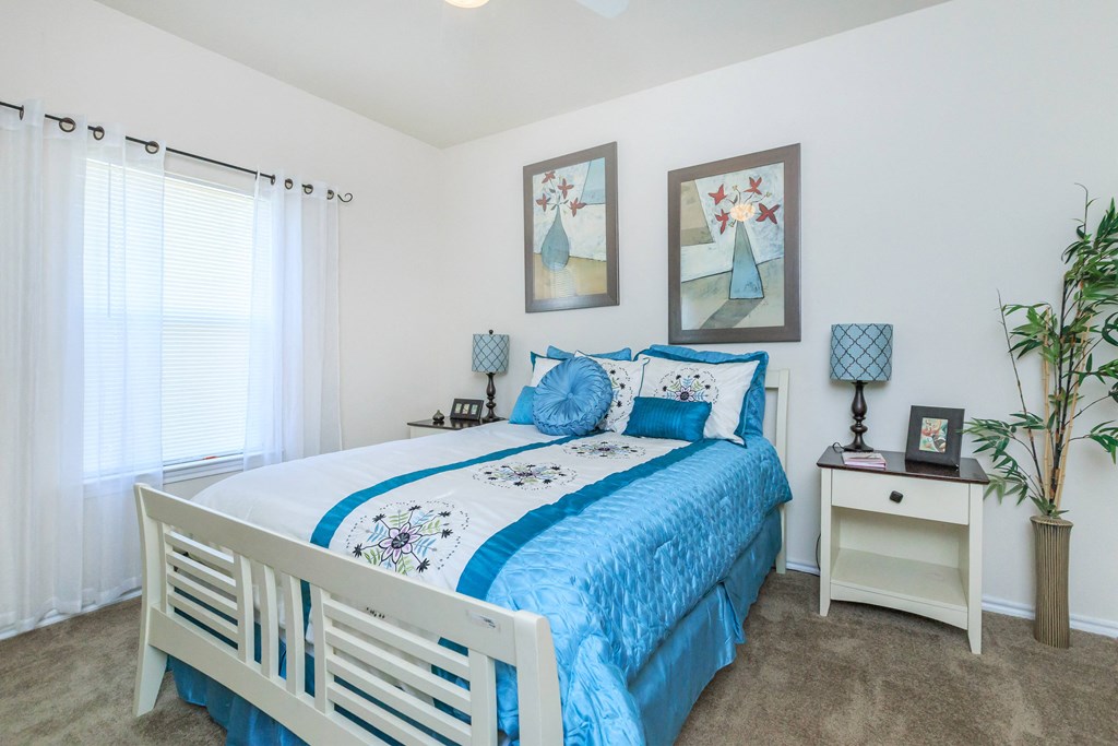a bedroom with a white bed and blue comforter