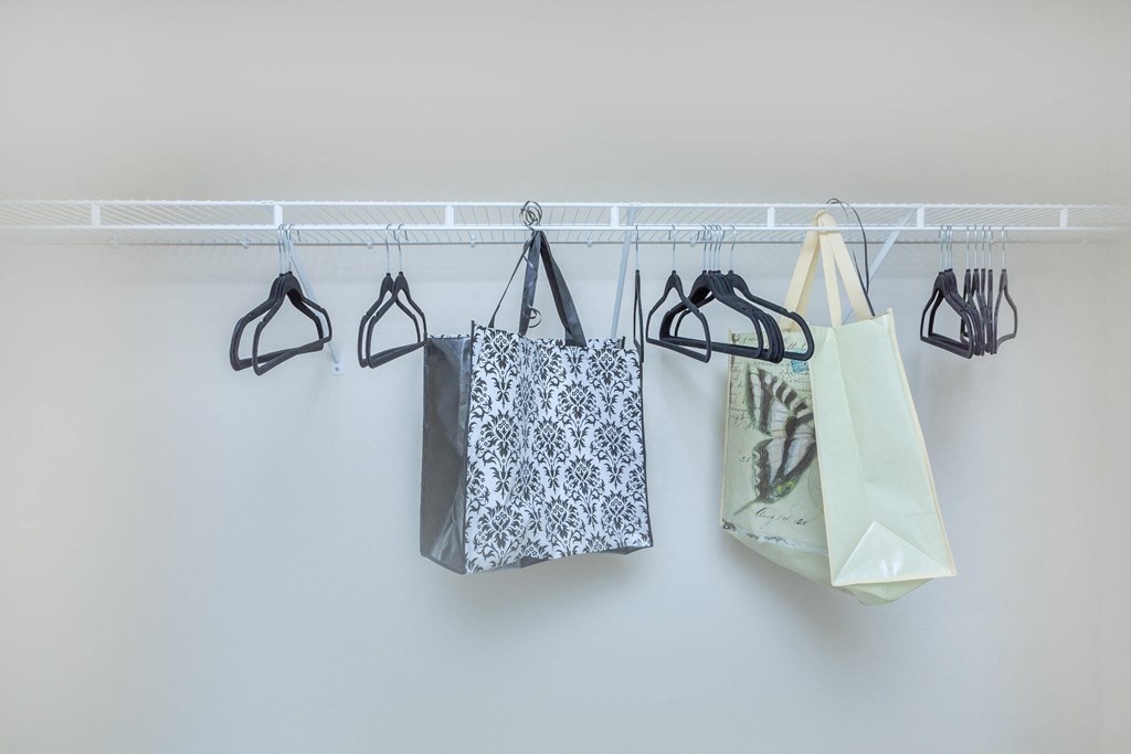 a row of bags hanging from a rack on a wall
