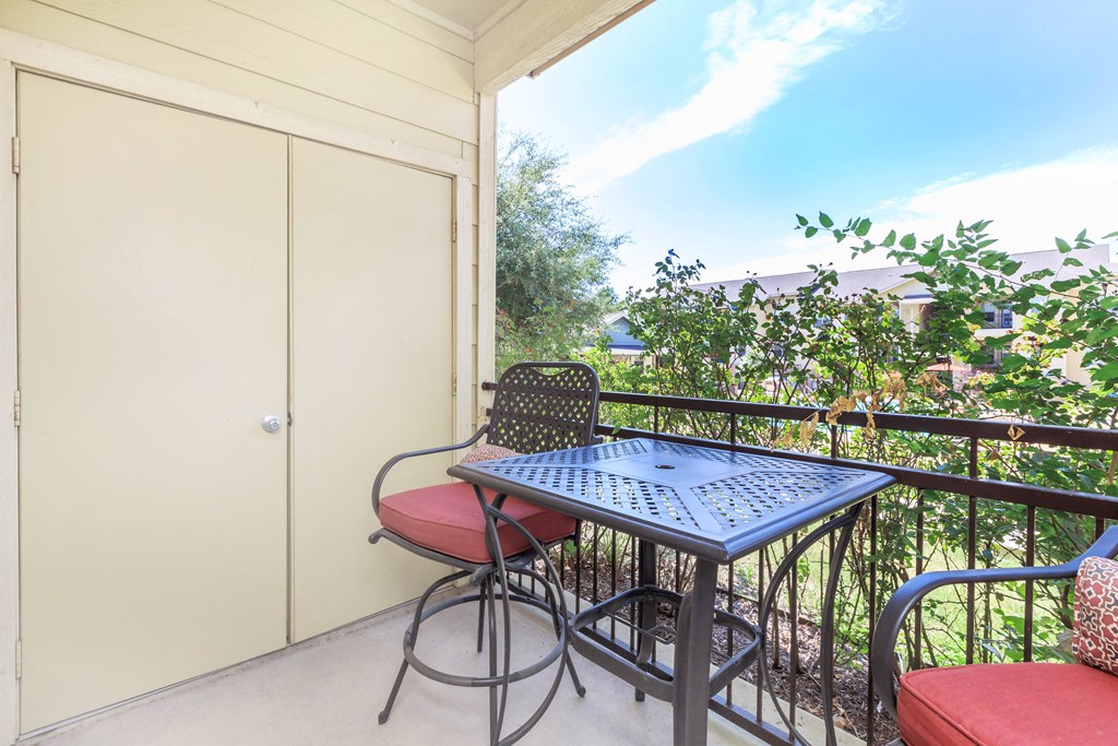 a patio with a table and chairs on the balcony