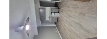 A room with a ceiling fan and a bed in the background. at Villa La Paz Apartments, California, 90706