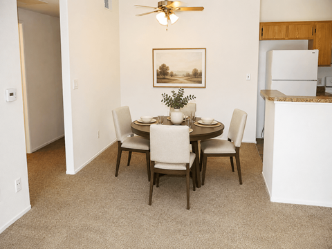A dining room with a table set for four at Riverview Springs, Oceanside, CA