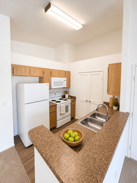 A kitchen with a bowl of green apples on the counter at Riverview Springs, Oceanside, CA