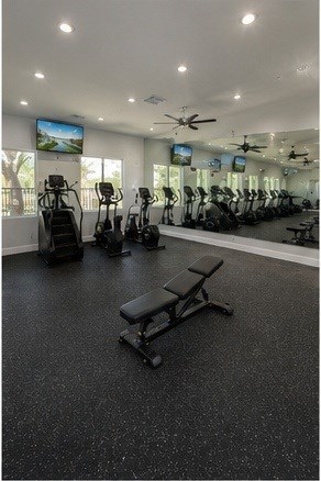 A gym with a variety of equipment including treadmills, exercise bikes, and weight benches at Vineyard Springs Apartments in Johnson City, TX, 78636