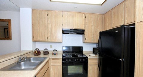 a kitchen with black appliances and wooden cabinets
