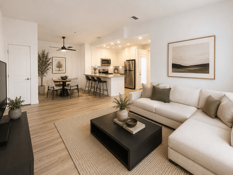 A modern living room with a white couch, a black coffee table, and a dining table with chairs.