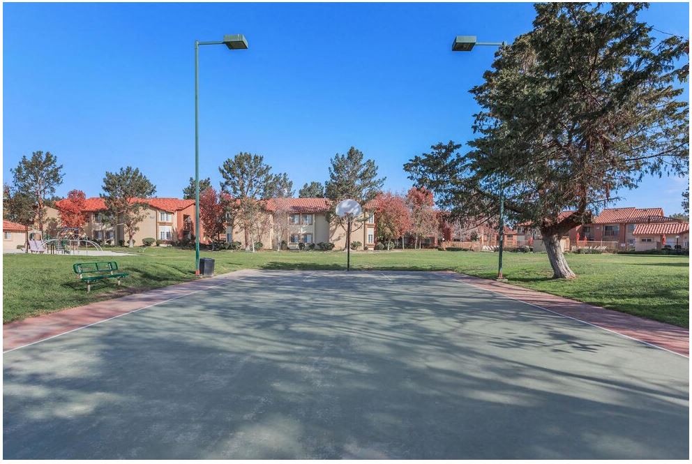 a parking lot with trees and buildings in the background at Riverview Springs, Oceanside, California