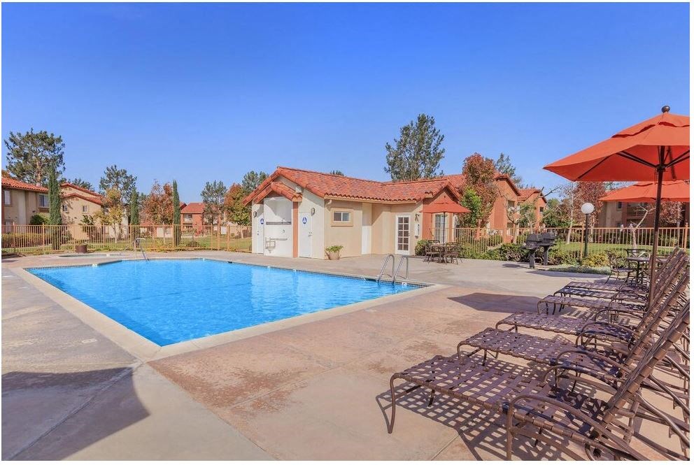 a pool with chairs and umbrellas next to a pool at Riverview Springs, Oceanside, CA