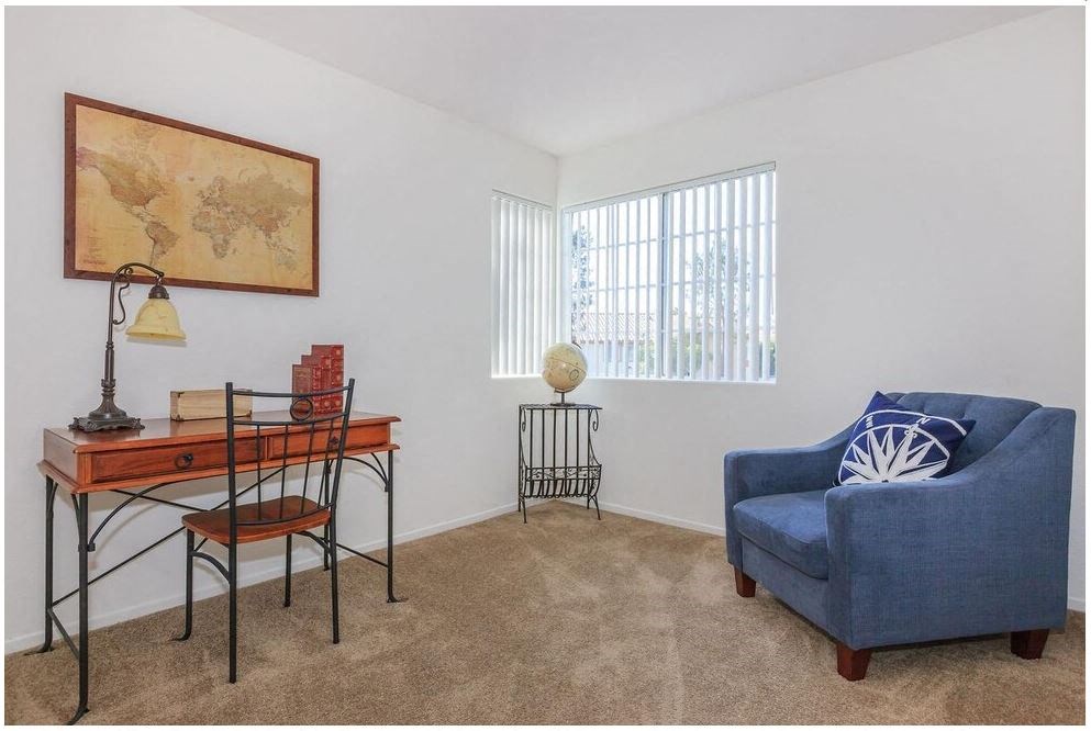 a living room with a blue chair and a desk at Riverview Springs, Oceanside, CA