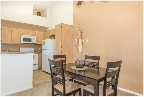 a kitchen and a dining room with a table and chairs