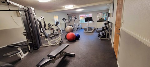 a gym with cardio equipment and exercise balls on the floor at Villa La Paz Apartments, California, 90706