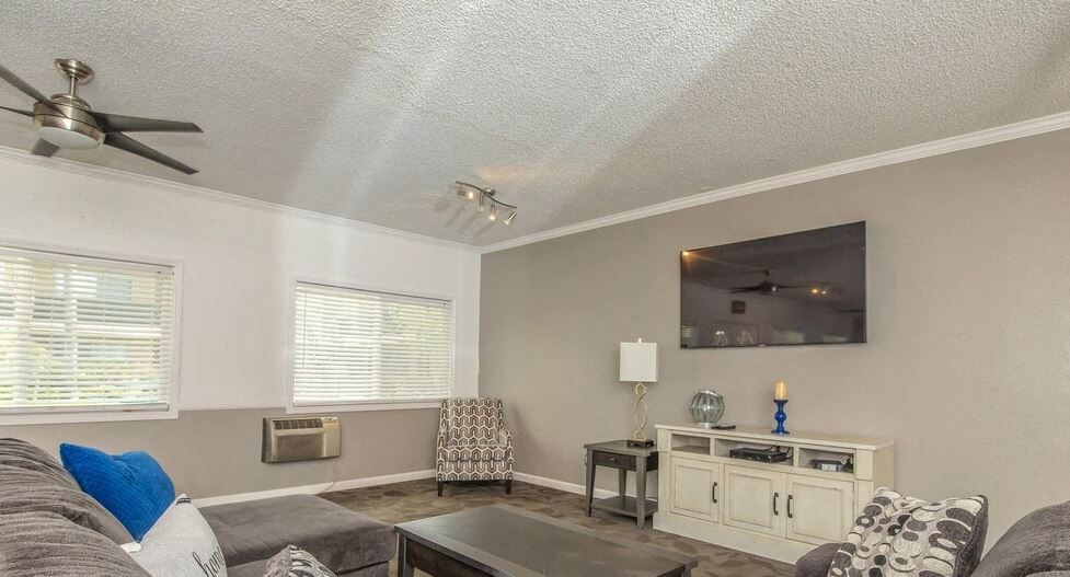 a living room with a couch and a tv at Villa La Paz Apartments, Bellflower, CA