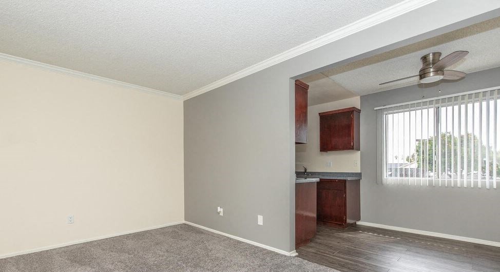 an empty living room with a ceiling fan at Villa La Paz Apartments, Bellflower, California