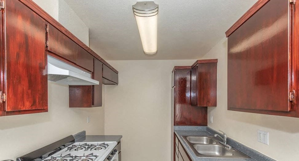 a kitchen with a stove and a sink at Villa La Paz Apartments, Bellflower