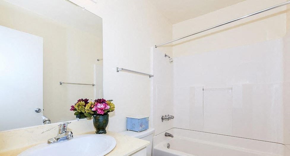 a white bathroom with a sink and a mirror and a shower at Villa La Paz Apartments, California, 90706