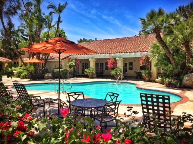 a swimming pool in front of a house with a pool table and umbrella at Victoria Springs, Riverside California