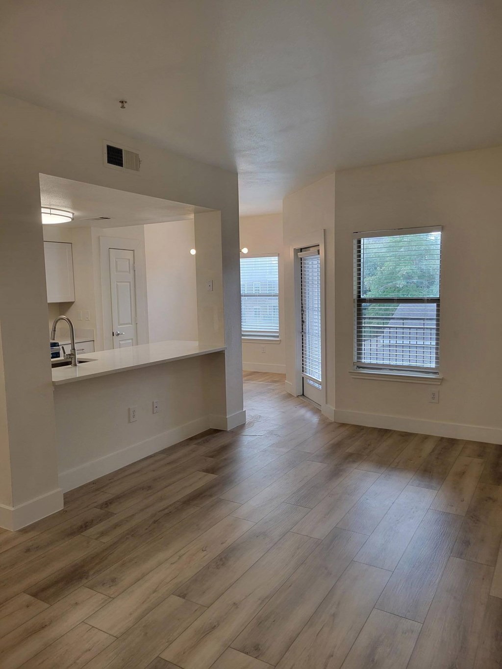 A room with wooden flooring and white walls.