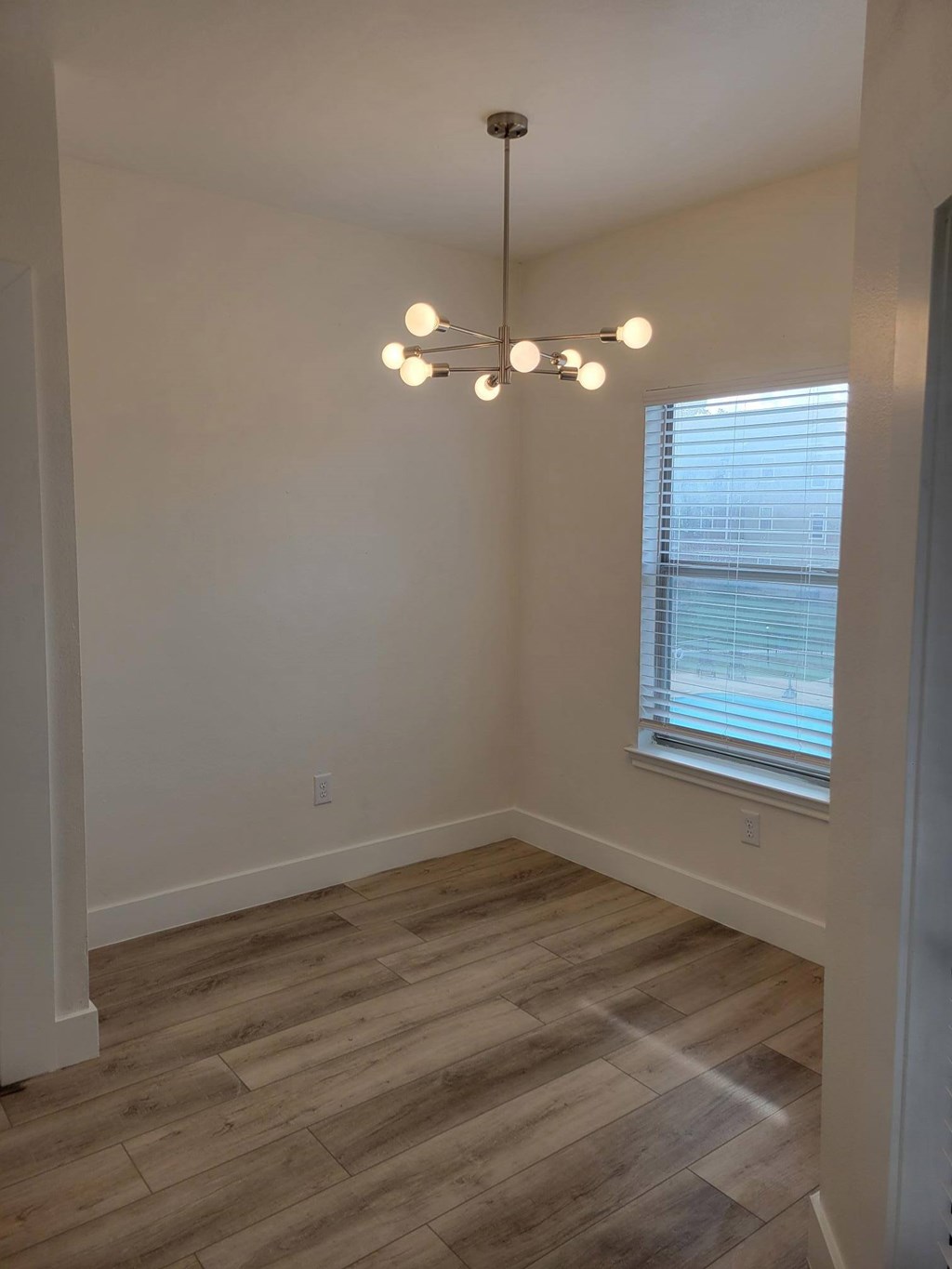 A room with a window and a chandelier.