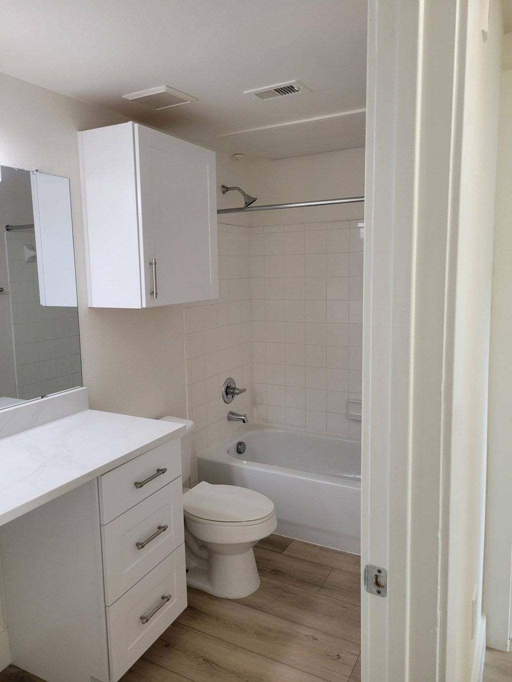 A white bathroom with a toilet, sink, and bathtub.